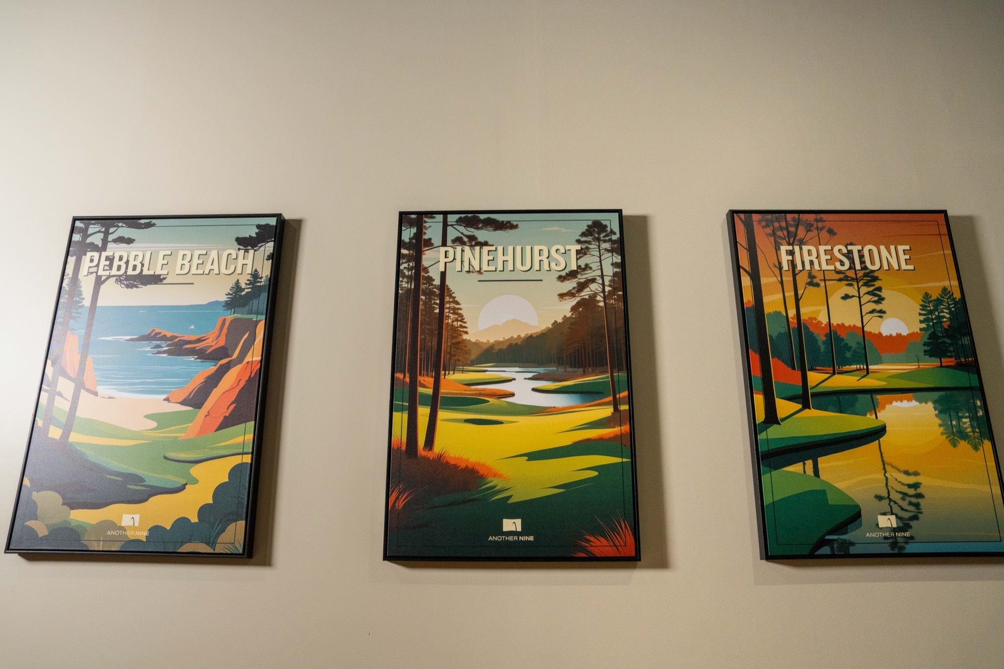 Framed golf-course art prints in an Another Nine facility